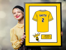 Load image into Gallery viewer, a woman holding up a framed picture of a jersey