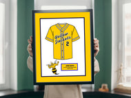 a person holding a framed picture of a baseball uniform